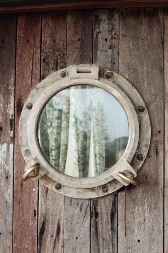 a window on a wooden wall with trees in it at Two Swans in Brunswick Heads