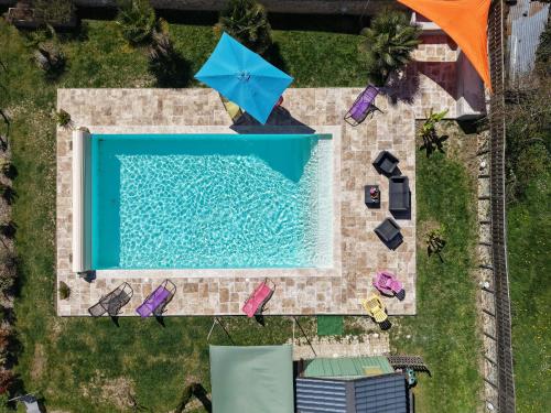 - une vue sur la piscine avec un parasol bleu dans l'établissement Maison avec piscine chauffée, bain nordique et grand jardin près d'Argenton-sur-Creuse - FR-1-591-63, à Le Menoux