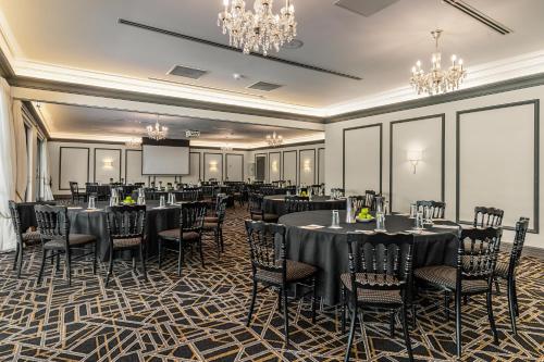 a banquet room with tables and chairs and a screen at Peppers Manor House in Sutton Forest