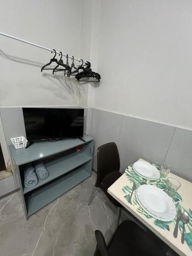 a room with a table and a shelf with plates on it at Residencial JC II sua casa em Belém do Pará in Belém