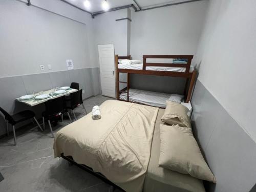 a small room with a bed and a table with a table at Residencial JC II sua casa em Belém do Pará in Belém