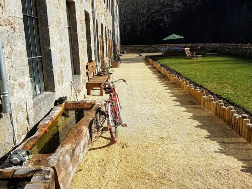 a bike parked next to a building with a bench at Grand gîte rénové, billard, baby-foot, vue sur rivière, terrasse, activités diverses - FR-1-582-76 in Le Chambon-sur-Lignon
