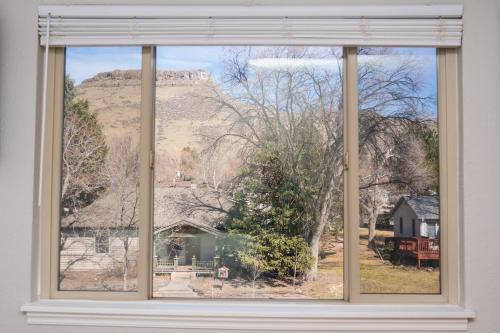 a window with a view of a house and a mountain at 10 min to Red Rocks KING BED Bike Storage DT Golden in Golden