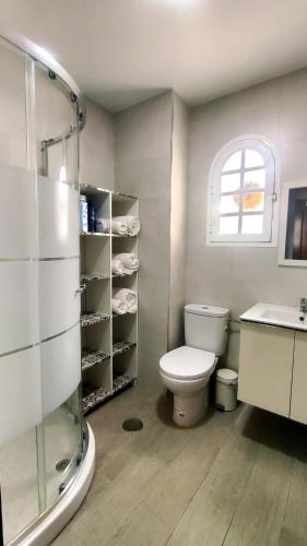 a bathroom with a toilet and a sink and a window at PISO AURORA in Barbate