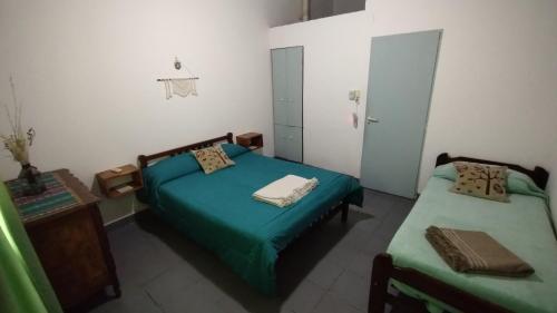 een kleine kamer met twee bedden en een spiegel bij Linaje Hospedaje in Colón