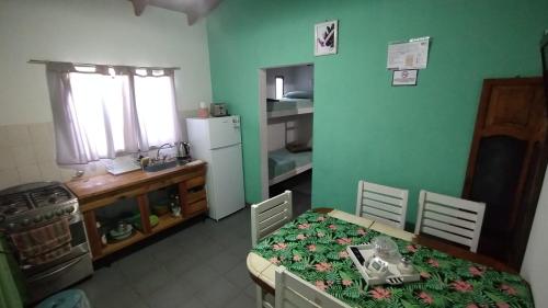 een keuken met een tafel en een keuken met een koelkast bij Linaje Hospedaje in Colón