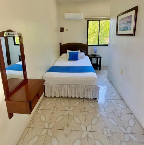 a bedroom with a bed and a mirror in it at Hotel Casa Blanca in Tlacotalpan