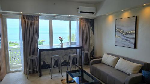 a living room with a couch and a bar with windows at La Mirada Residences in Mactan
