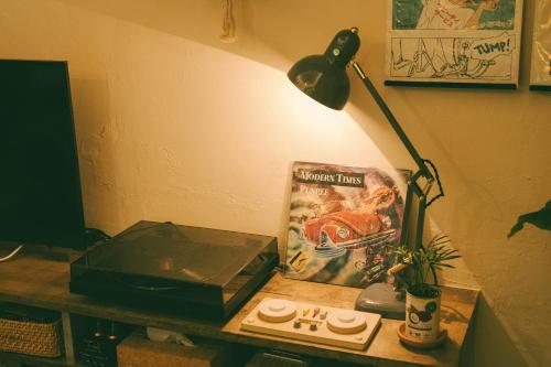 a desk with a lamp and a book and a box at 天然温泉つきの ちいさな貸別荘 little villa 柊日 in Azumino