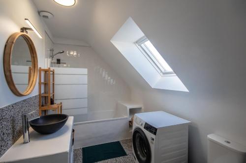 La salle de bains est pourvue d'un lave-linge et d'une lucarne. dans l'établissement L'escapade Maison familiale 3 étoiles jardin & vue mer, proche plage, à Plérin