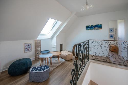 Cette chambre dispose d'un escalier avec une table et des chaises. dans l'établissement L'escapade Maison familiale 3 étoiles jardin & vue mer, proche plage, à Plérin