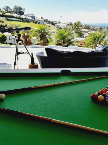 a pool table with a cue and balls on it at Breeze Kiama in Kiama