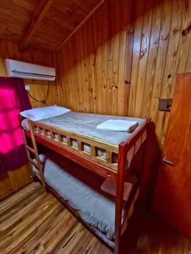 a bunk bed in a cabin with wooden walls at Terra Iguazú Cabañas in Puerto Iguazú