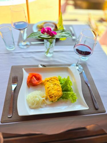 a plate of food on a table with a glass of wine at Terra Iguazú Cabañas in Puerto Iguazú