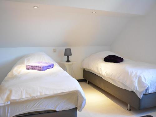 2 Betten in einem Schlafzimmer mit weißer Bettwäsche und lila Handtüchern in der Unterkunft Lake-view apartment with sauna, hot tub in Grand Coo