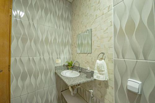 un bagno con lavandino e specchio di Casa no Perequê Guarujá c/ Wi-Fi e Churrasqueira a Bertioga