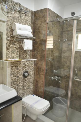a bathroom with a shower and a toilet and a sink at Hotel Grand Parkway in Tambaram