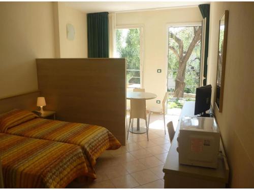 a bedroom with a bed and a table and a window at Studio für 4 Personen in Imperia in Imperia