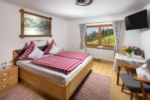 a bedroom with a bed with red and white pillows at Pension Scheuerbichl in Bischofswiesen