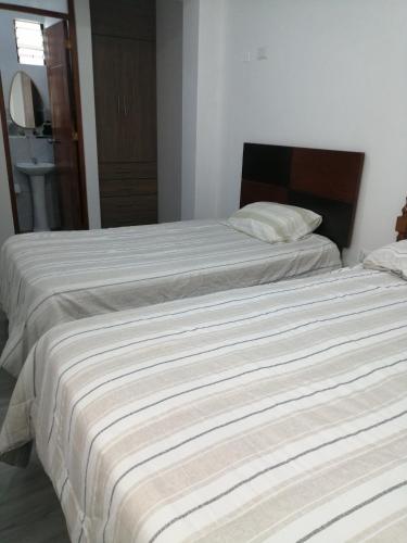 Dos camas una al lado de la otra en un dormitorio. en Alojamiento Miller, en Ayacucho
