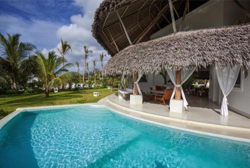 a resort with a swimming pool and a thatched building at The Kasa Malindi in Malindi