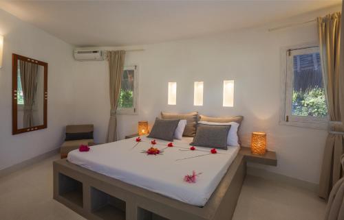 a bedroom with a large white bed with flowers on it at The Kasa Malindi in Malindi