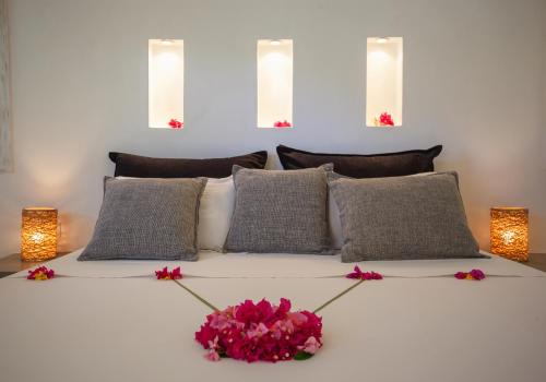 a white bed with pink flowers on top of it at The Kasa Malindi in Malindi