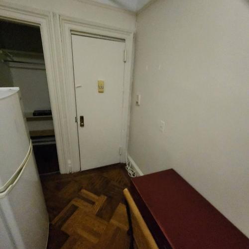 an empty room with a door and a table in it at New York City Guest House 2 in New York