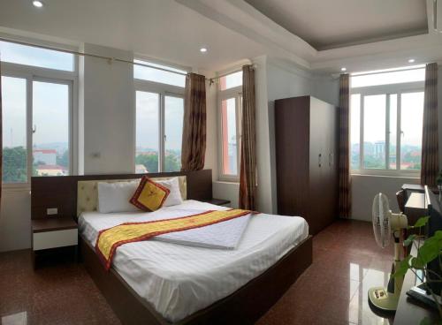 a bedroom with a large bed with large windows at Crown Hotel in Thái Nguyên