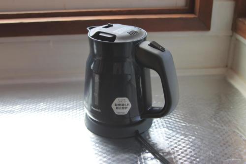 a black coffee pot sitting on a counter at Ataata Resort in Iga