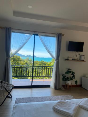 a bedroom with a bed and a large window at The moon camp khanom in Ban Plau