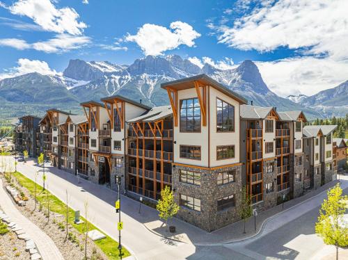 a row of apartment buildings with mountains in the background at Spring Creek Luxury King One Bedroom at White Spruce Lodge in Canmore