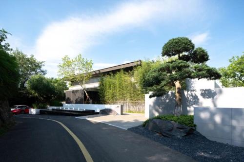 a house with a tree on the side of a road at FU VALLEY Hotel in Liyang