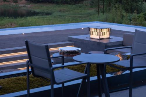 a patio with three chairs and a table and a grill at FU VALLEY Hotel in Liyang