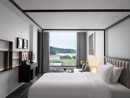 a hotel room with a large bed and a large window at FU VALLEY Hotel in Liyang