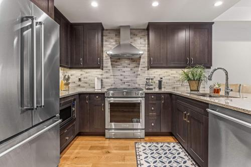 a kitchen with wooden cabinets and stainless steel appliances at Spring Creek Luxury King One Bedroom at White Spruce Lodge in Canmore