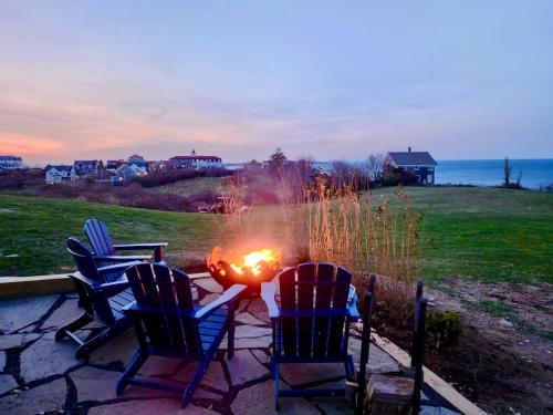 a fire pit with three chairs sitting around it at Harbor Point Haven in New Shoreham