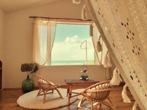 a room with two chairs and a table and a window at furaha in Iwamicho