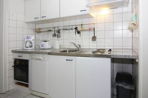 a kitchen with white cabinets and a sink at Apartment für 3 in Metelsdorf in Metelsdorf