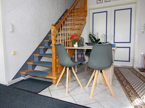 a dining room with a staircase and two chairs at Apartment für 3 in Metelsdorf in Metelsdorf