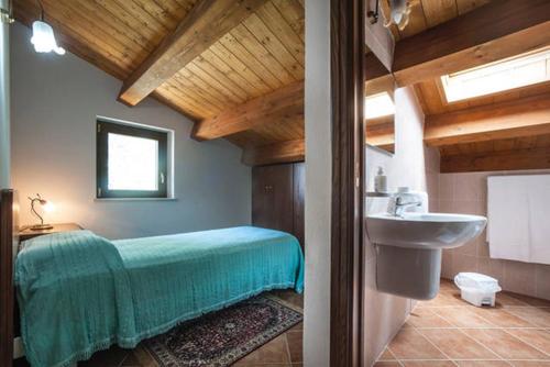 baño con cama verde y lavabo en Agriturismo Miracco Atanasio Franco "Il Maniero" en Santa Sofia dʼEpiro