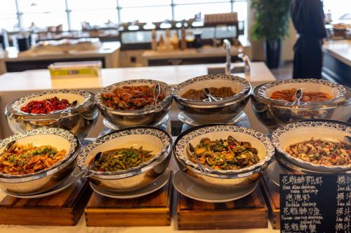 a bunch of bowls of food on a table at 青岛海天大酒店 山海相拥典雅奢华 in Qingdao