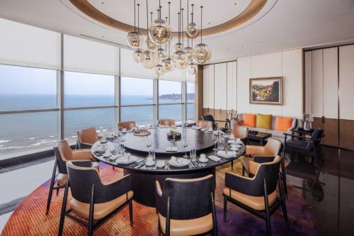 a dining room with a large table and chairs at 青岛海天大酒店 山海相拥典雅奢华 in Qingdao