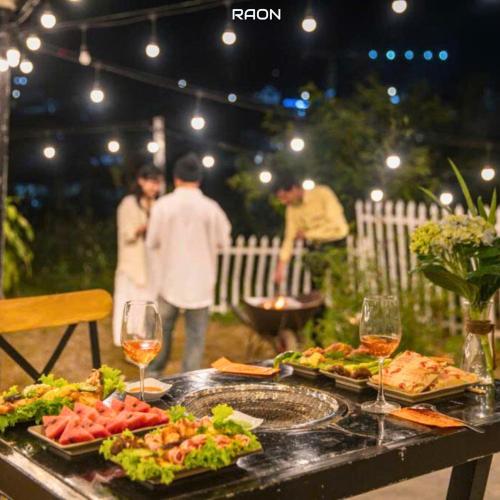 a table with plates of food and glasses of wine at Ami Villa Dalat in Da Lat