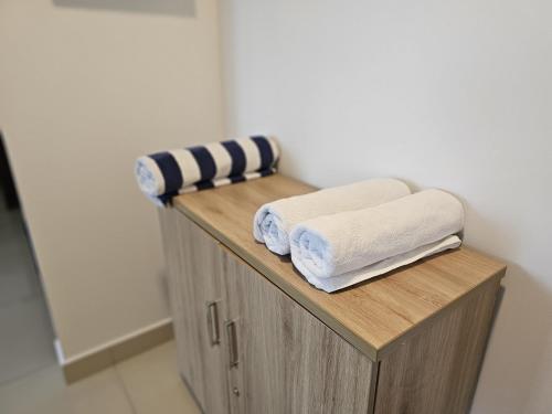 a wooden shelf with towels on it in a bathroom at Ocean Breeze Sea View Luxury Apartments in Negombo