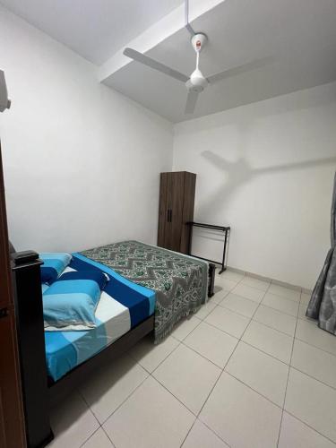 a bedroom with a bed and a ceiling fan at TDH Homestay #5 in Kangar