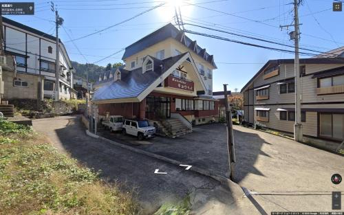 un edificio con un'auto parcheggiata di fronte di Sunshine Kyohei a Nozawa Onsen
