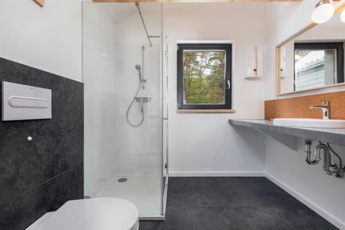 a bathroom with a shower and a toilet and a sink at Holiday Home by Lake Wise ka near Baltic Beach in Wisełka