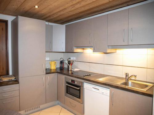 une cuisine avec des armoires blanches et un évier dans l'établissement Appartement 3 chambres aux Gets avec balcon exposé sud, proche pistes et centre - FR-1-671-99, aux Gets