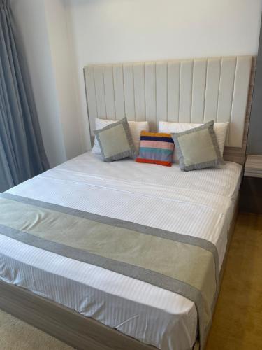 a bed with three pillows on top of it at Ocean Breeze Sea View Luxury Apartments in Negombo